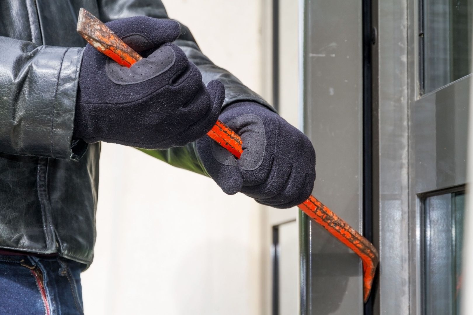 Ein Mann mit einem Brecheisen versucht in ein Haus einzubrechen
